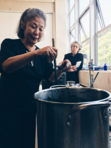 Yoshiko stirring the vat in a forceful circular motion. Photo Courtesy: Anu Ravi